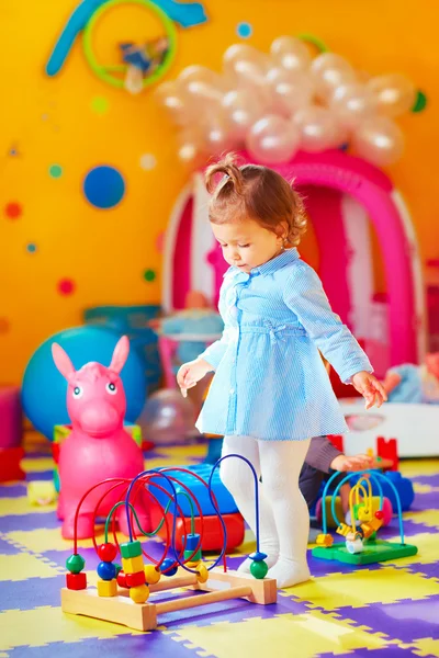 Schattig klein meisje spelen met speelgoed in de kleuterschool — Stockfoto