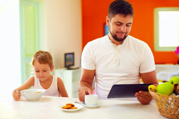 Pai e filho tomando café da manhã na cozinha em casa — Fotografia de Stock