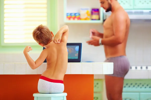 Padre e hijo por la mañana en sus tareas diarias en la cocina —  Fotos de Stock