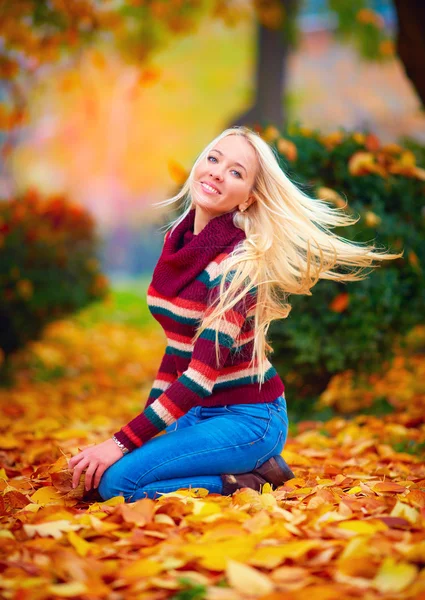 Beautiful girl having fun in autumn park among vibrant leaves — Stock Photo, Image