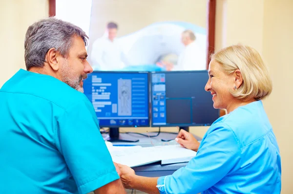 Expérimenté trucs médicaux adultes parler du diagnostic du patient dans la salle de tomographie — Photo