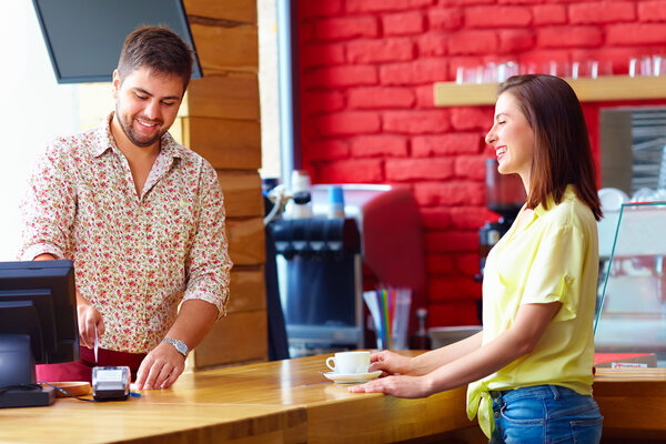 cashier serves customer at the cash desk in cafe