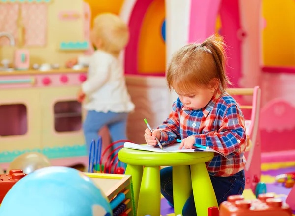 Schattig klein meisje tekenen met potlood in de kleuterschool — Stockfoto