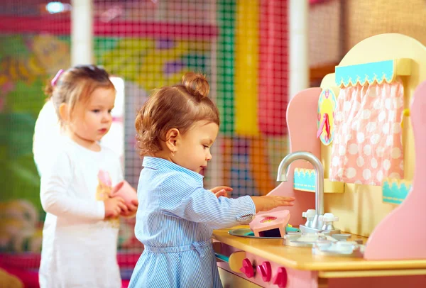 Meninas brincando na cozinha de brinquedos no jardim de infância — Fotografia de Stock