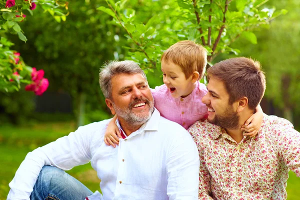 Portrait of happy grandpa, father and son in spring garden — Stock Photo, Image