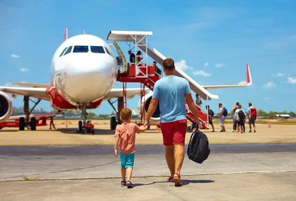 Familia caminando para embarcar en avión en el aeropuerto, vacaciones de verano —  Fotos de Stock