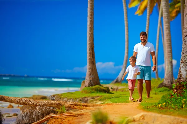 Gelukkig vader en zoon lopen op het paradise island — Stockfoto