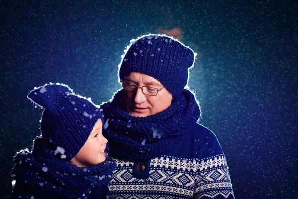 Šťastný dědeček a vnuk mluví za večer sněhu — Stock fotografie