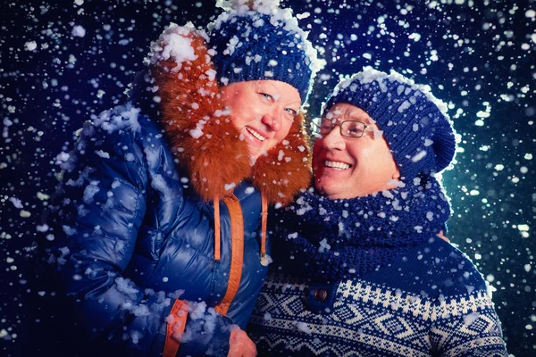 Feliz pareja madura bajo la nieve —  Fotos de Stock