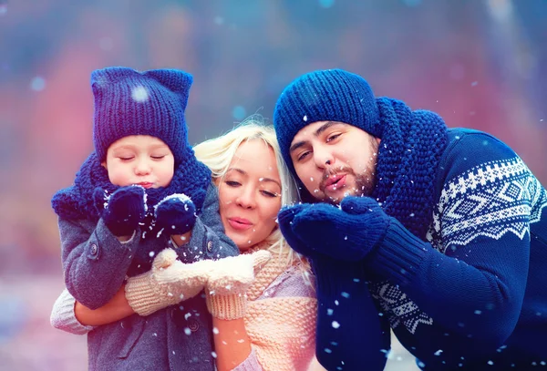 Portrait of happy family blowing winter snow outdoors — Stock Photo, Image