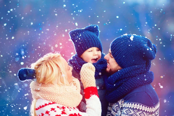Feliz familia divirtiéndose bajo nieve de invierno, temporada de vacaciones — Foto de Stock