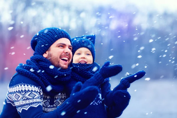 Pai feliz e filho se divertindo sob neve de inverno, temporada de férias — Fotografia de Stock
