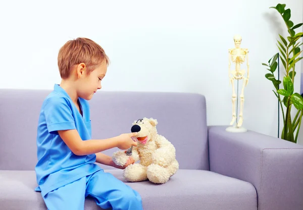 Bonito jovem garoto jogar um médico no escritório — Fotografia de Stock