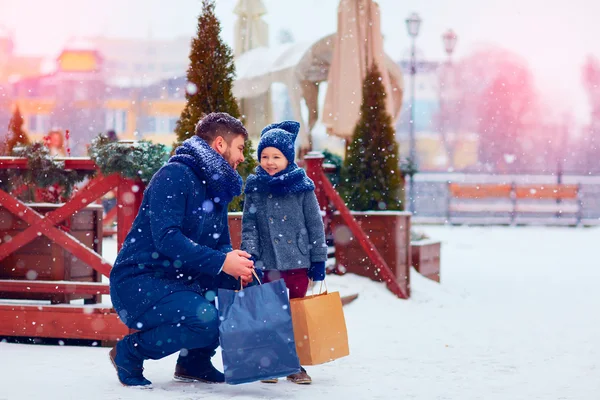 Father and son on winter shopping in city, holiday season, buying presents — Stock Photo, Image