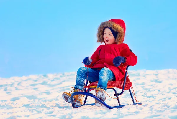 Enfant heureux glissant en descente sur la neige d'hiver — Photo