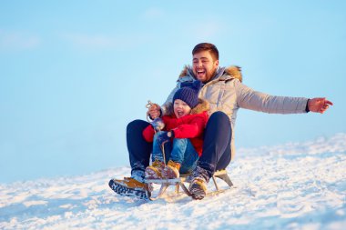 mutlu aile yokuş aşağı kış kar üzerinde kayar