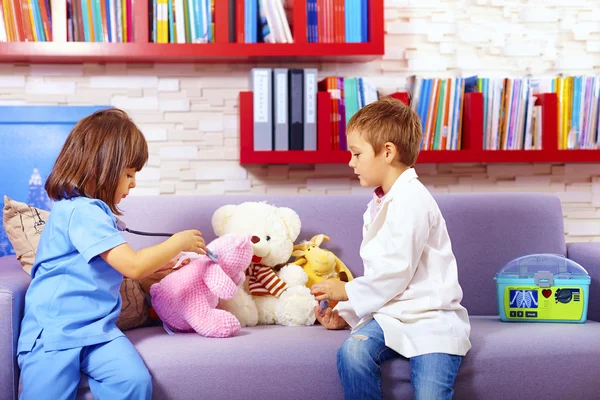 Roztomilé děti hrají lékaři s hračkami v úřadu — Stock fotografie