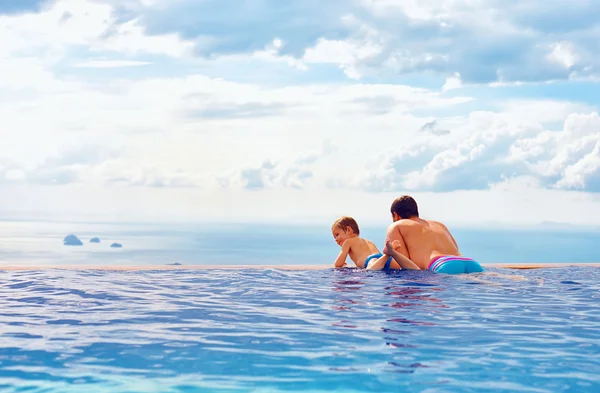 Happy father and son enjoy beautiful seascape from infinity pool, vacation concept — Stock Photo, Image