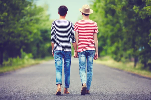 Gay couple marche loin ensemble sur printemps route — Photo