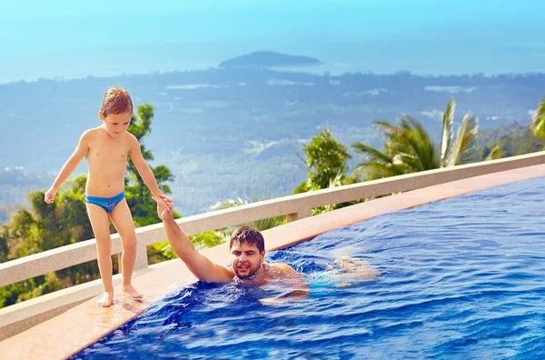Šťastný otec a syn relaxační v nekonečný bazén na tropickém ostrově — Stock fotografie