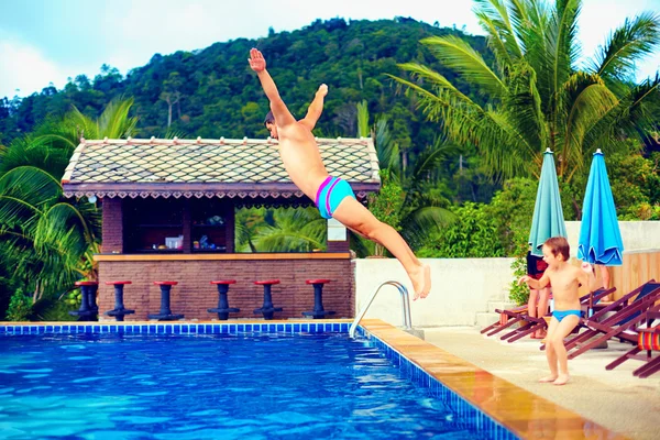 Familia divirtiéndose en la piscina en vacaciones tropicales —  Fotos de Stock