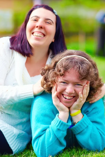 Retrato de mujeres felices con discapacidad en el césped de primavera —  Fotos de Stock