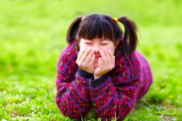 Menina feliz com deficiência no gramado da primavera — Fotografia de Stock