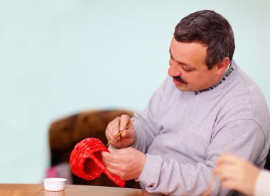 Rehabilitasyon merkezinde zanaat iş yapan genç yetişkin adam
