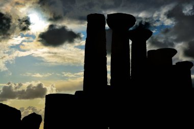 Herkül Tapınağı 'nın silueti kasvetli bir gökyüzünün altında. Tapınaklar Vadisi, Agrigento, Sicilya