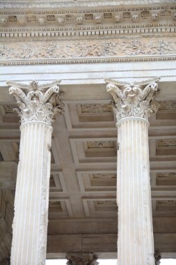 Fransa 'nın Nimes kentindeki Antik Roma Tapınağı' nın zamirlerindeki iki Korint Sütununun başkenti ve kuşatması