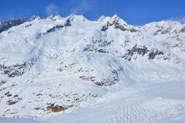 İsviçre 'deki Bernese Alpleri' ndeki Aletsch Buzulu 'nun üzerinde Schinhorn, Sattelhorn ve Aletschhorn' dan (l 'den r' ye) kar damlaları yükseliyor. Unesco tarafından korunan bir bölge