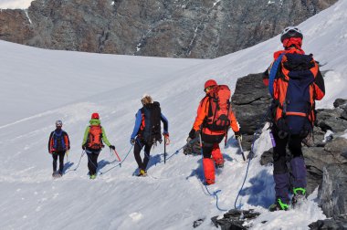 Team of climbers descends from the summit clipart