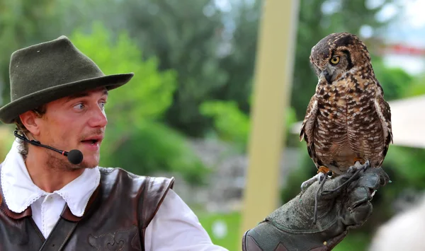 Falkner hält eine gefleckte Eule in der Hand — Stockfoto