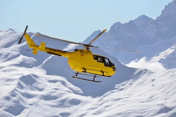 A rescue helicopter in snow covered mountains — Stock Photo, Image