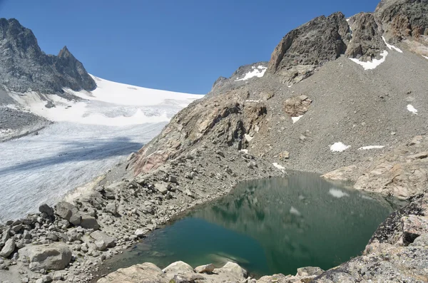 Un lago creado entre la ladera de la montaña — Foto de Stock