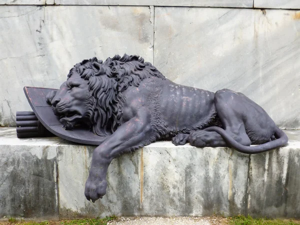 Bronze statue of a wounded lion — Stock Photo, Image