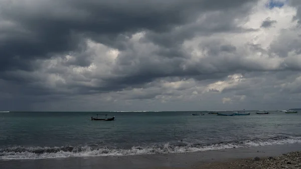 海上的风暴 海滩上的渔船 在印度尼西亚下雨前 天空乌云密布 免版税图库照片
