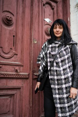 Kapının önünde güzel bir yetişkin kadın, Avrupa 'da seyahat ediyor, terk edilmiş evde eski bir köy kapısı, içeri girmek için kapıyı çalan biri..