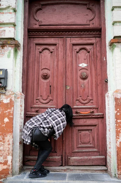 一个女人偷看门 一个人打开一个古老的门 古老的欧洲建筑 图库图片
