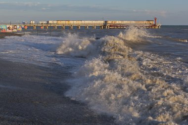 Resort yerleşim Adler ve arka plan üzerinde batan güneşin pier kıyısında kırma dalgalar deniz