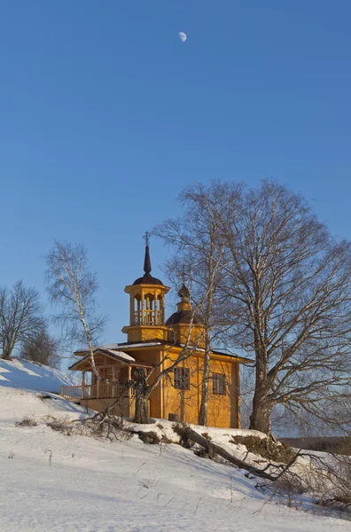 Wooden chapel on a sunny winter day on a background blue sky with the moon. Village Markovskaya Verkhovazhsky District Vologda Region, Russia — Stock Photo, Image