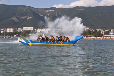 Gelendzhik, Krasnodar bölgesi, Rusya Federasyonu - 16 Temmuz 2015: yolcu şişme muz sıçramasına uçan el salla. Gelendzhik Körfezi'Beach etkinlikler