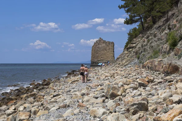 Люди идут вдоль берега Черного моря, чтобы плыть Скала — стоковое фото