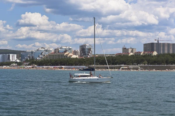 Weiße Jacht im Schwarzen Meer auf einem Hintergrund Wohnkomplex "Wasserfläche" in gelendzhik, Region Krasnodar, Russland — Stockfoto