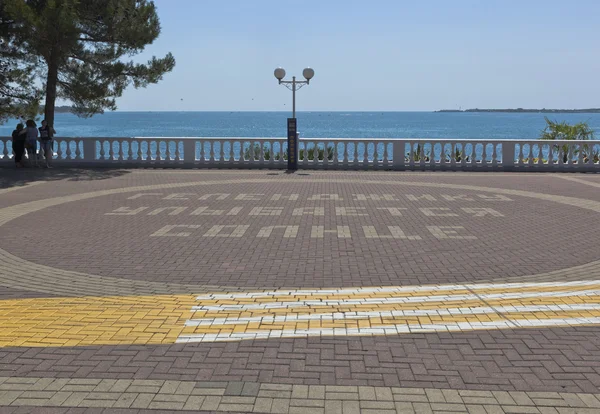 Inscriptie op de kinderkopjes van waterfront resort stad van Gelendjik "Gelendjik zon glimlachen" — Stockfoto