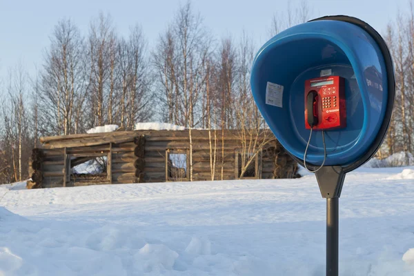 Payphone sullo sfondo rovinata casa in legno nel bosco russo — Foto Stock