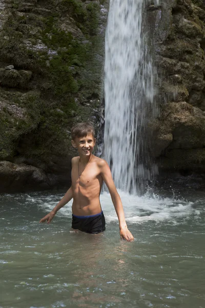 Gelukkige jongen aangezien iedereen wordt overspoeld in koud water van de waterval Cool — Stockfoto