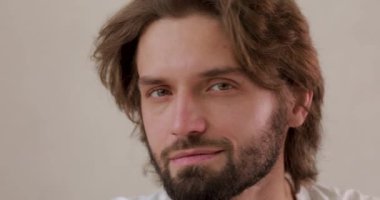 Kameraya bakan yakışıklı bir gencin portresi. Yüzüne dokunuyor ve temiz cildiyle tatmin olmuş görünüyor. Sağlık ve hijyen kavramı.