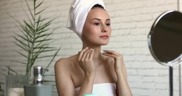 Friska ung kvinna med klar hud gör massage för ansikte med fingrar efter morgondusch. Vacker dam i badhandduk njuter av dagliga förfaranden hemma. — Stockvideo