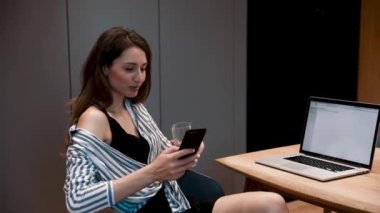 Mutlu bir iş kadını portresi ev telefonunda başarıya ulaşır. Kapalı çekim neşeli kız telefonda iyi haberleri ağır çekimde okuyor. Apartmanda zaferi kutlayan sürpriz kadın..